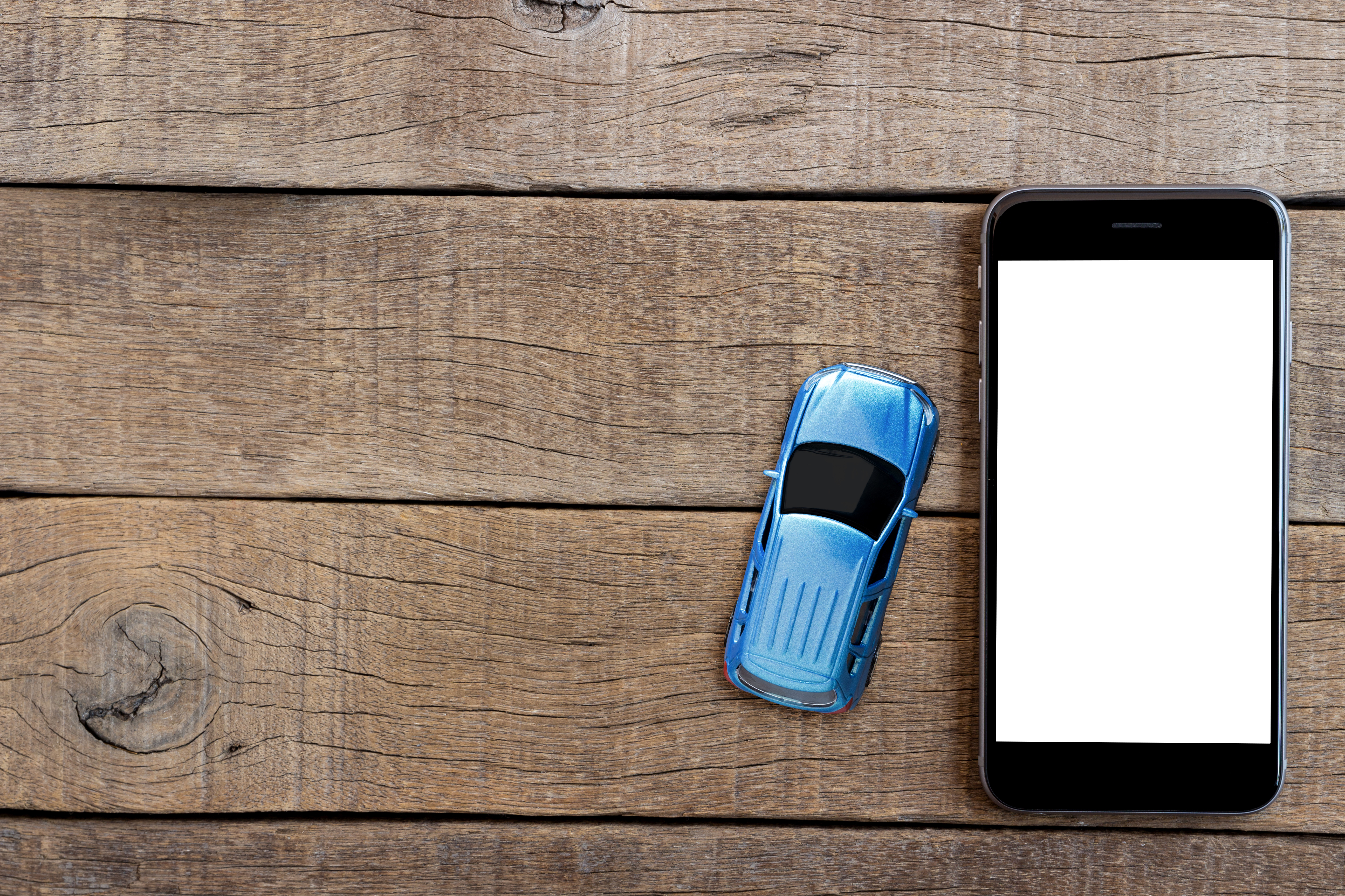 Phone,And,Car,Model,Toy,On,Wood,Table,Top,View