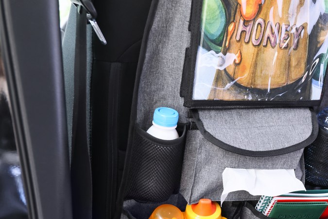 Organizador de viajes con diferentes cosas en el asiento del coche en salón