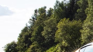 El Ferrari 12Cilindri 2025 acelerando en una carretera despejada, con su V-12 rugiendo mientras el paisaje pasa a toda velocidad.