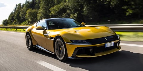 El Ferrari 12Cilindri 2025 acelerando en una carretera despejada, con su V-12 rugiendo mientras el paisaje pasa a toda velocidad.