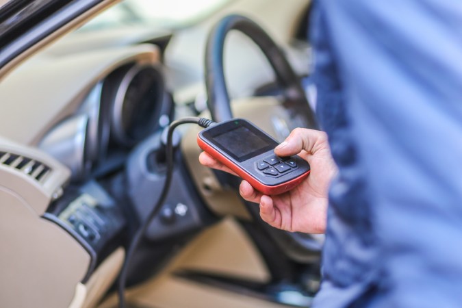 Escáner OBD-II conectado al auto para apagar la luz de advertencia del motor fácilmente