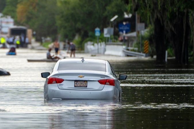 carretera inundada con vehículo estancado