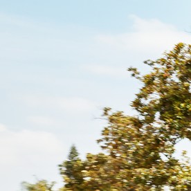 Mitsubishi Outlander Sport 2025 color naranja atravesando un vecindario local