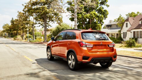 Mitsubishi Outlander Sport 2025 color naranja atravesando un vecindario local
