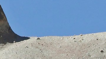 Dos Toyota Hilux 2025 sobre fondo rocoso. Una en color gris y otra en color vino