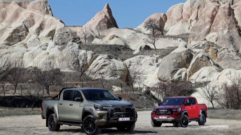 Dos Toyota Hilux 2025 sobre fondo rocoso. Una en color gris y otra en color vino
