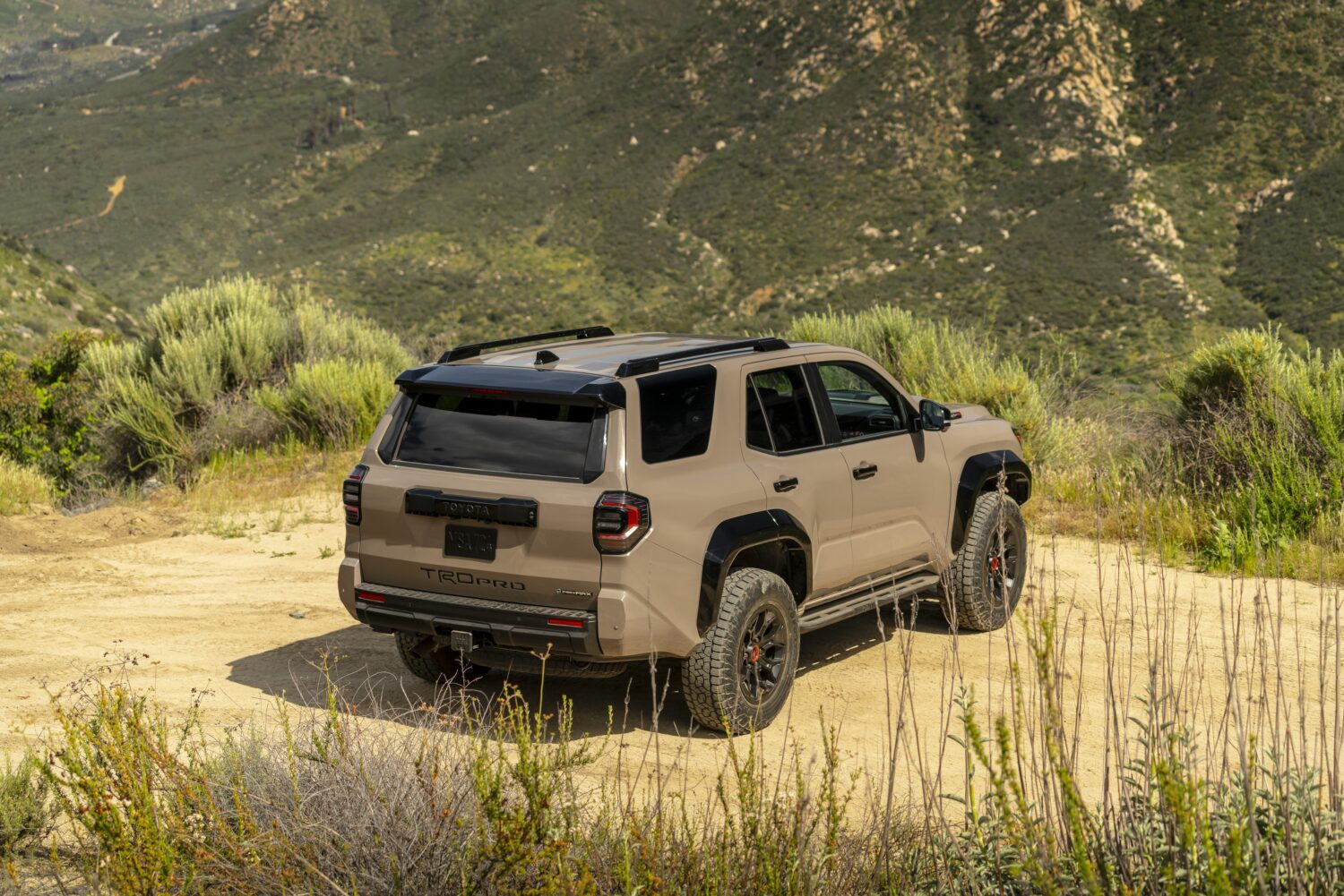 Toyota 4runner TRD Pro 2025 en un camino de montaña, rodeada de vegetación y colinas.
