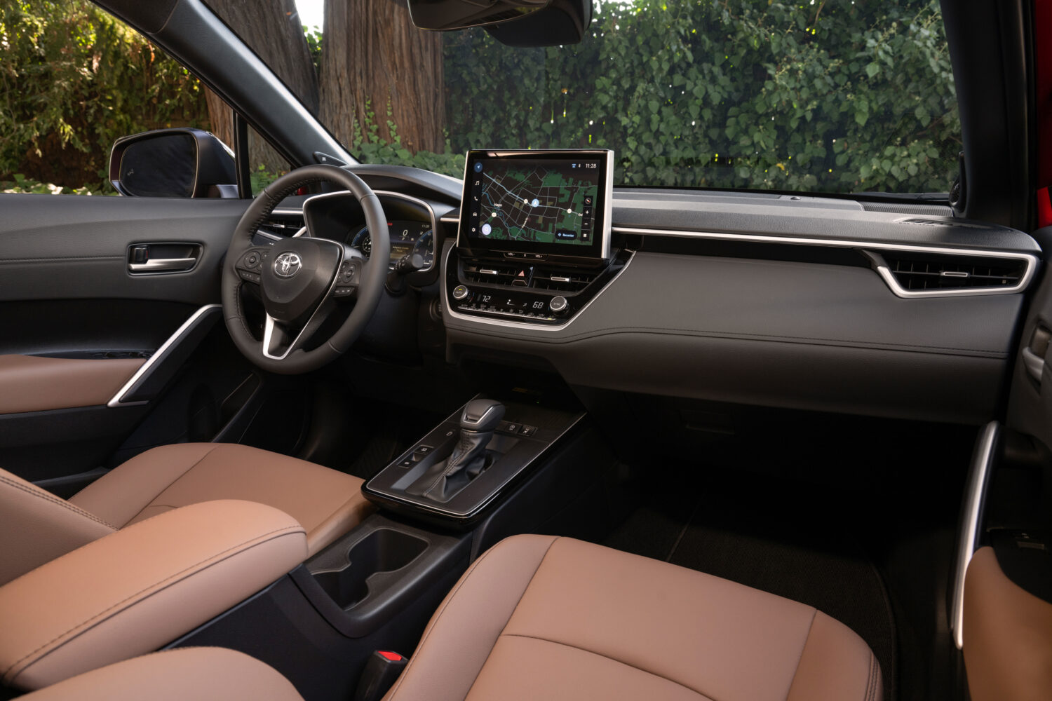 Interior del Toyota Corolla Cross 2026 con diseño moderno, pantalla táctil central y asientos bicolor en cuero, destacando confort y tecnología avanzada.