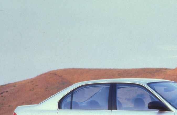 Honda Civic 1997, gris, entorno rocoso, diseño elegante, ángulo trasero, terreno árido.