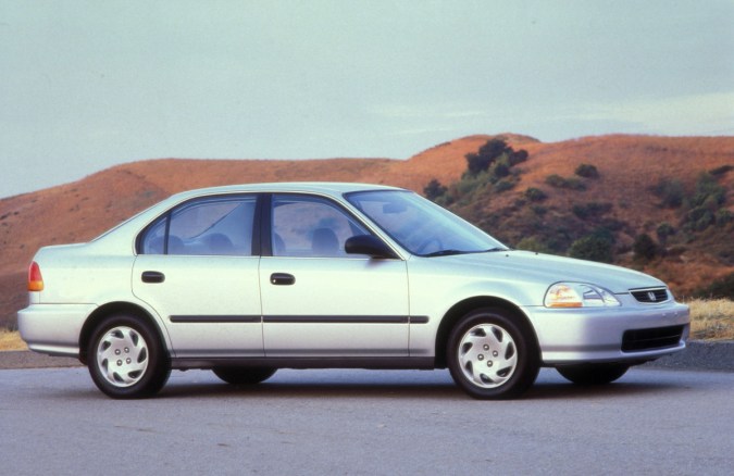 Honda Civic 1997, gris, entorno rocoso, diseño elegante, ángulo trasero, terreno árido.