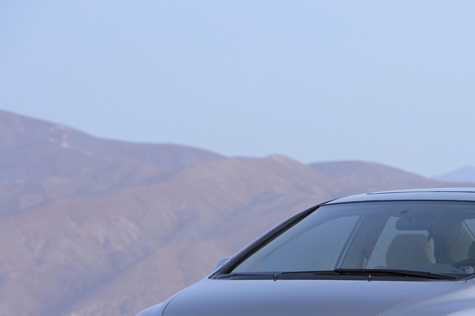 Vista frontal de un Honda Civic sedán de octava generación, color plateado, estacionado en una carretera con montañas al fondo.