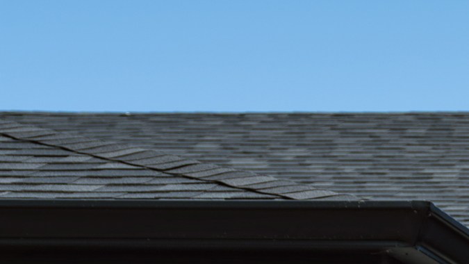 Tesla Model Y Standard de color azul estacionado frente a un garaje