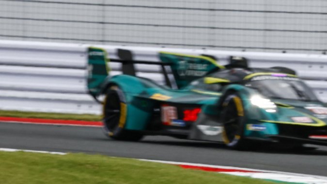 Competición de autos Porsche 963 en un circuito al aire libre con varios competidores.