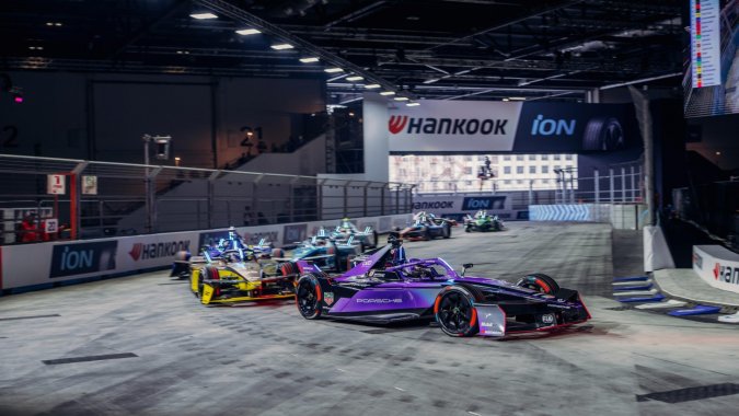 Carreras de autos eléctricos de Formula E en un circuito cubierto con publicidad de Hankook y Porsche.