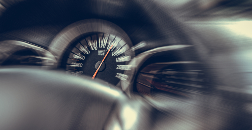 Velocímetro de auto en movimiento, enfoque en velocidad