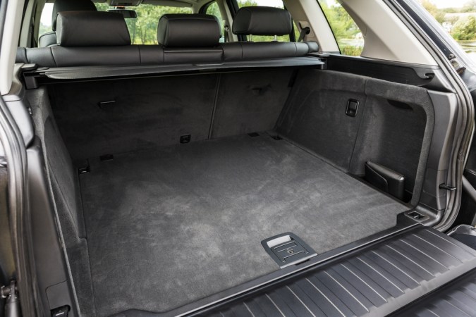 gran maletero abierto de un coche moderno con alfombrado en condiciones de desgaste
