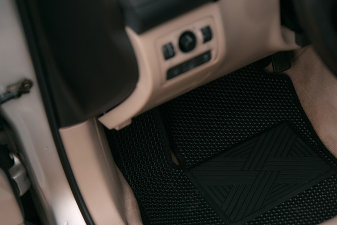 Coche de lujo con decoración de cuero blanco con alfombras de suelo EVA de alta calidad en color negro. Cierre de la alfombra negra del suelo del coche de acetato de etileno.