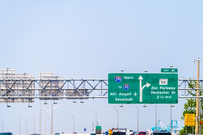Autopista interestatal 295 de Florida con señal de tráfico al aeropuerto internacional i-95 de Savannah y Zoo Parkway con autos conduciendo en verano