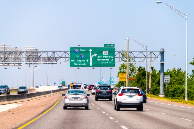 Autopista interestatal 295 de Florida con señal de tráfico al aeropuerto internacional i-95 de Savannah y Zoo Parkway con autos conduciendo en verano