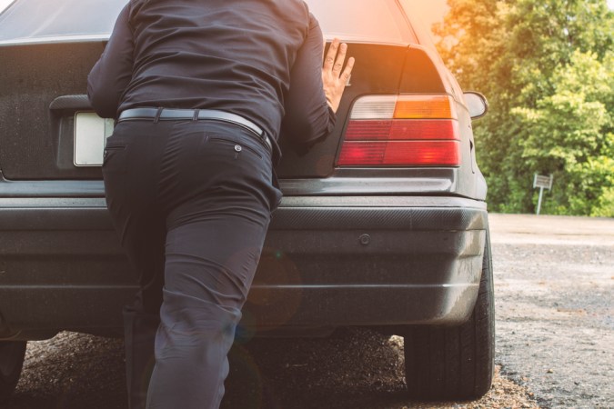 Vista trasera de carro automático siendo empujado, evidenciando práctica peligrosa para la caja.