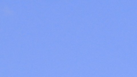 Una toma de una tienda Walmart con coches en el estacionamiento con cielo azul y nubes