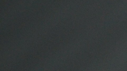 Rosa roja sobre capó de auto blanco, detalle brillante bajo luz suave.