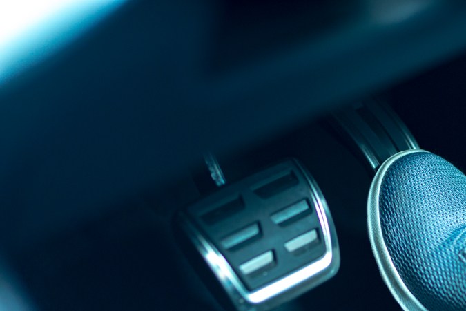 Pie en pedal de freno de auto, iluminación azul