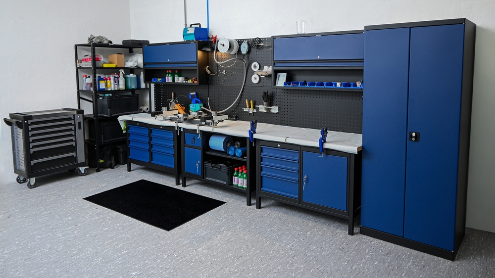 Área de taller organizada que muestra bancos de trabajo, gabinetes de almacenamiento y varias herramientas, encarnando la eficiencia.