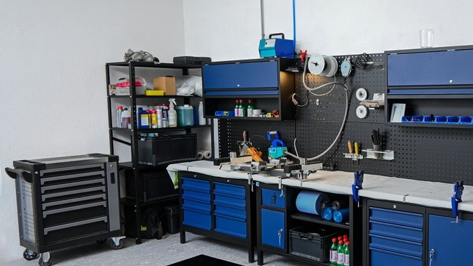 Área de taller organizada que muestra bancos de trabajo, gabinetes de almacenamiento y varias herramientas, encarnando la eficiencia.