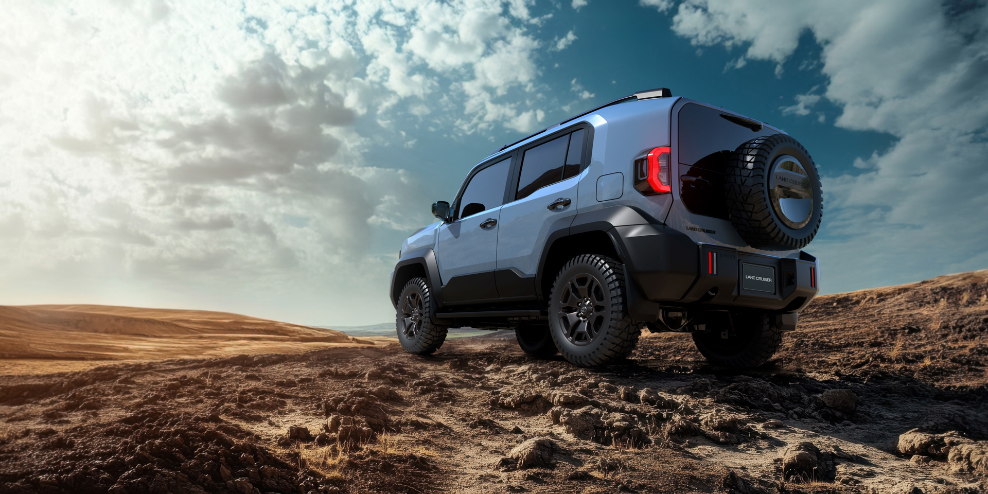 Toyota Land Cruiser FJ azul 2025: vista trasera off-road con rueda repuesto en desierto árido.