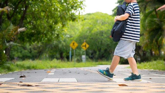 niño cruzando la calle en zona escolar
