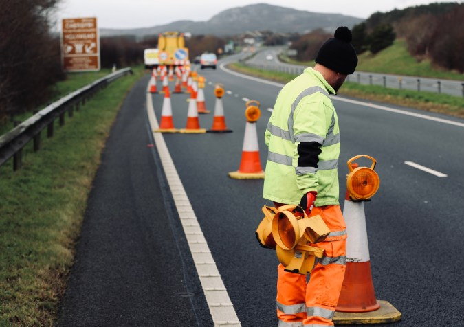 líneas con obreros trabajando en la carretera