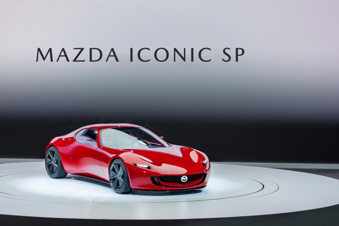 Mazda Iconic SP, auto conceptual rojo brillante en exhibición, diseño futurista.