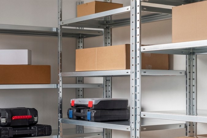 Estantes metálicos con cajas y maletines en garaje espacioso.