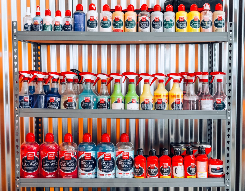 Estantes metálicos llenos de productos de limpieza en garaje industrial.