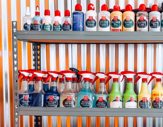 Estantes metálicos llenos de productos de limpieza en garaje industrial.