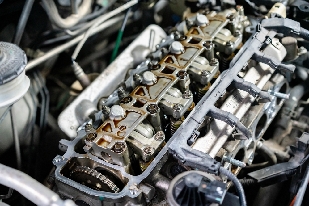 Motor de auto abierto mostrando válvulas y componentes, ideal para mantenimiento y reparación de humo en tapón de aceite.