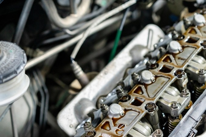 Motor de auto abierto mostrando válvulas y componentes, ideal para mantenimiento y reparación de humo en tapón de aceite.