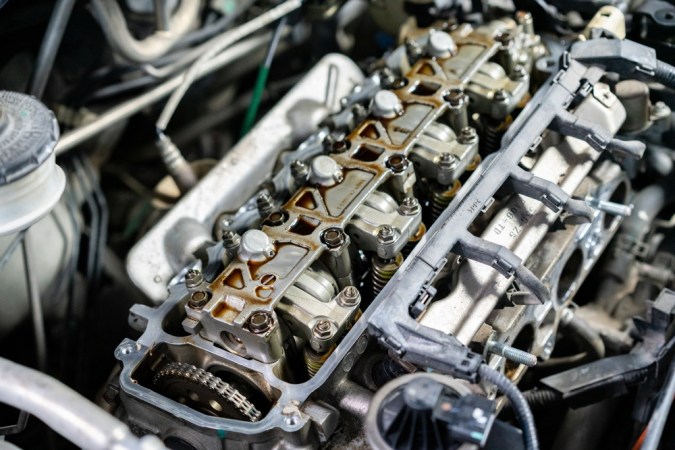 Motor de auto abierto mostrando válvulas y componentes, ideal para mantenimiento y reparación de humo en tapón de aceite.