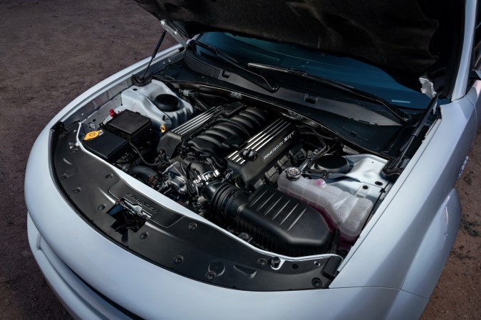 Motor HEMI V8 SRT bajo el capó de un Dodge Charger, mostrando detalles del sistema de admisión y componentes mecánicos.