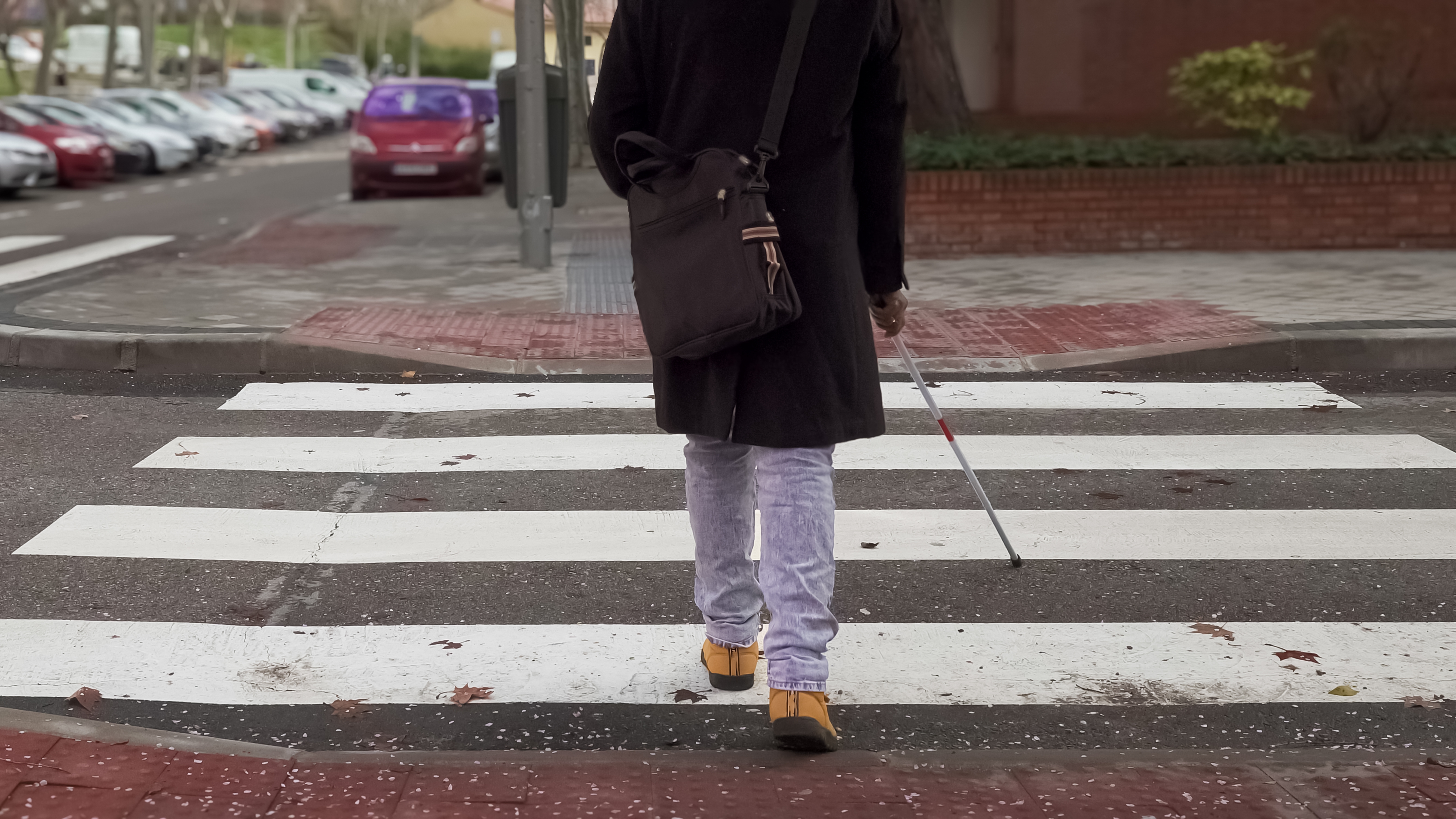 persona ciega cruzando un paso de peatones