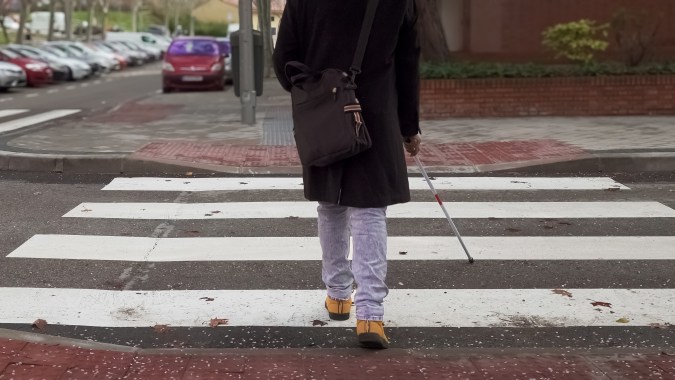 persona ciega cruzando un paso de peatones