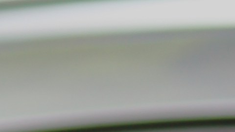 Auto gris con polarizado en ventanas, reflejando naturaleza, ideal para protección solar y diseño moderno.