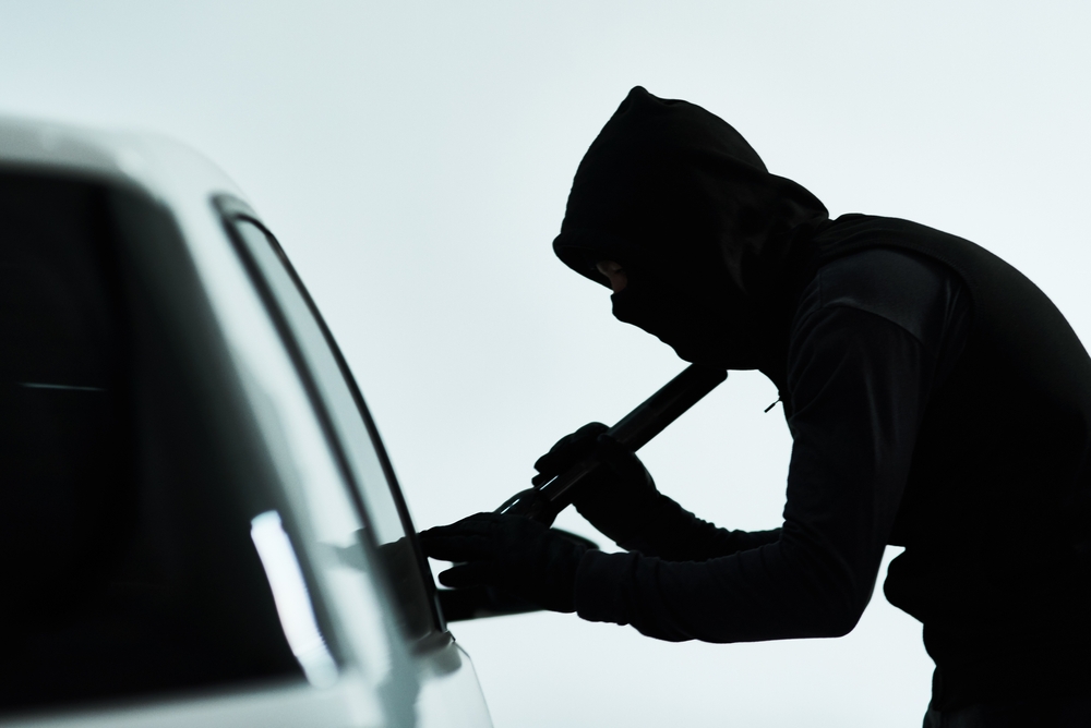 Hombre, coche y robo intento con criminal, automóvil y luz de destello o comprobar la posesión valiosa en el interior. Ilícito, evaluar vehículo y seguridad para sistema antirrobo, encapuchado y estacionamiento