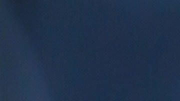 Ladrón afuera de un auto iluminando al interior