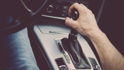 Detalle de una mano tirando de un selector de velocidades automático en un camión nuevo.