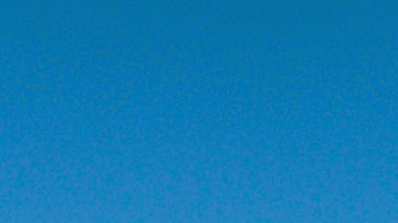 Una escena animada de tailgating con carpas coloridas, banderas y personas reunidas alrededor de vehículos en un campo de hierba, con un edificio de estadio de fondo bajo un cielo azul despejado.