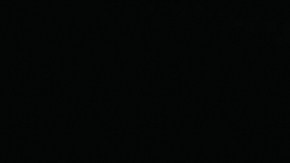 Primer plano de una mano activando el botón Start-Stop en la consola de un vehículo, con fondo oscuro y enfoque en el detalle