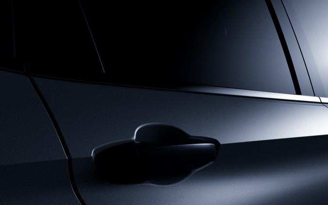 Vista lateral de un SUV moderno en un entorno oscuro, destacando el diseño elegante de las puertas y las ventanas tintadas.