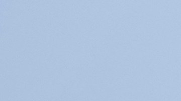 Chrysler Pacifica 2026 blanca frente a edificio histórico y banderas de Estados Unidos, minivan familiar estadounidense ideal para viajes urbanos y suburbanos.